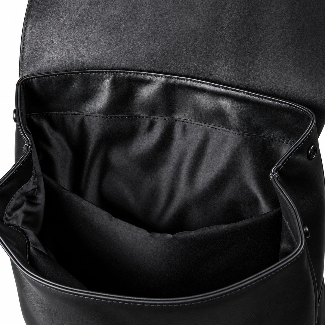 Close-up of the interior of a black leather or full-grain leather bag, showing a spacious open compartment with black lining and stitched edges.