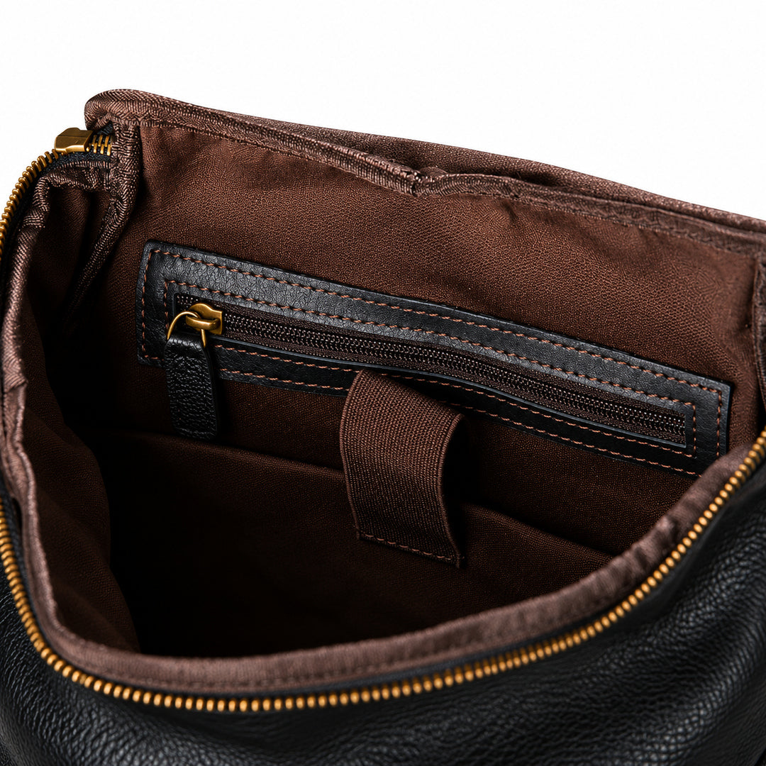 Black full-grain leather backpack interior with brown lining and a leather-trimmed zipper pocket