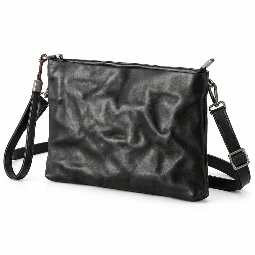 Black leather clutch bag with a crinkled texture, featuring a top zipper closure, a detachable wristlet strap, and a matching adjustable shoulder strap with silver hardware.