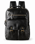 A black leather backpack with gold-tone hardware, featuring a front flap pocket with two buckle straps, a zippered top compartment, and side pockets.