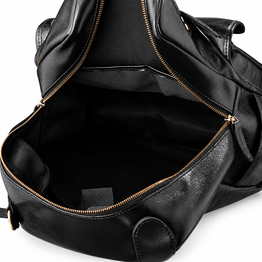 Black leather bag shown open to display the interior, featuring a black fabric lining and gold-tone zippers.
