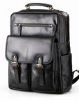 Black faux leather backpack with gold-tone hardware, featuring a top handle, front flap pocket with buckle straps, and side pockets.