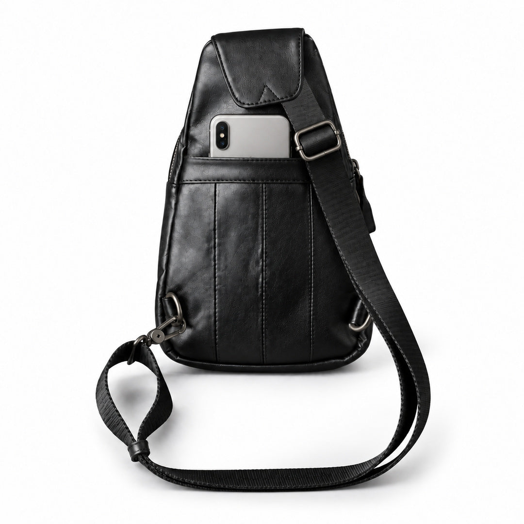Rear view of a black leather sling bag with a silver smartphone partially inserted into the back slip pocket.