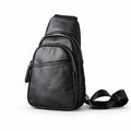 Black leather sling bag with two curved zip compartments and a front slip pocket, shown at a slight angle.