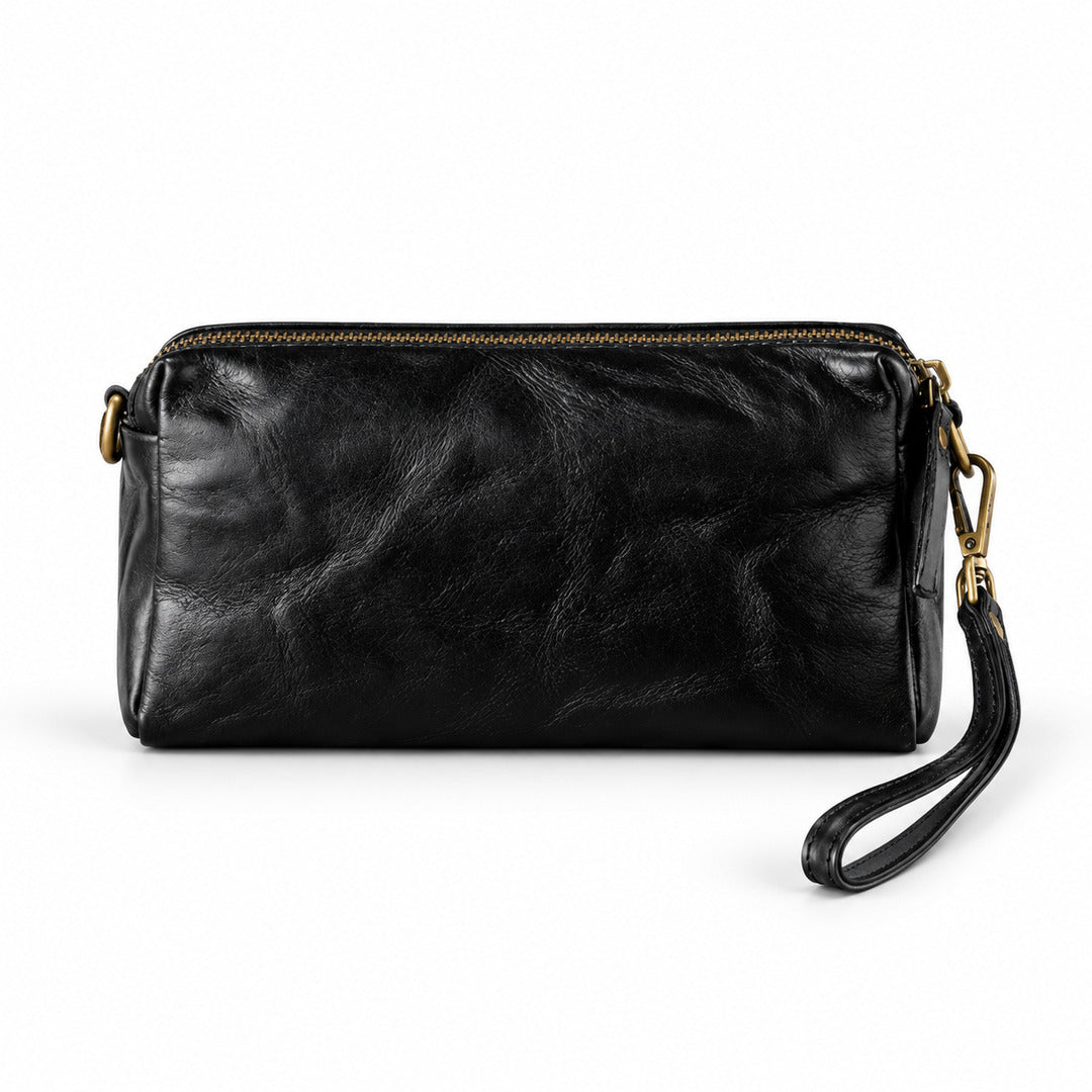 Black leather wristlet clutch with a top zipper and wrist strap, featuring gold-tone hardware.
