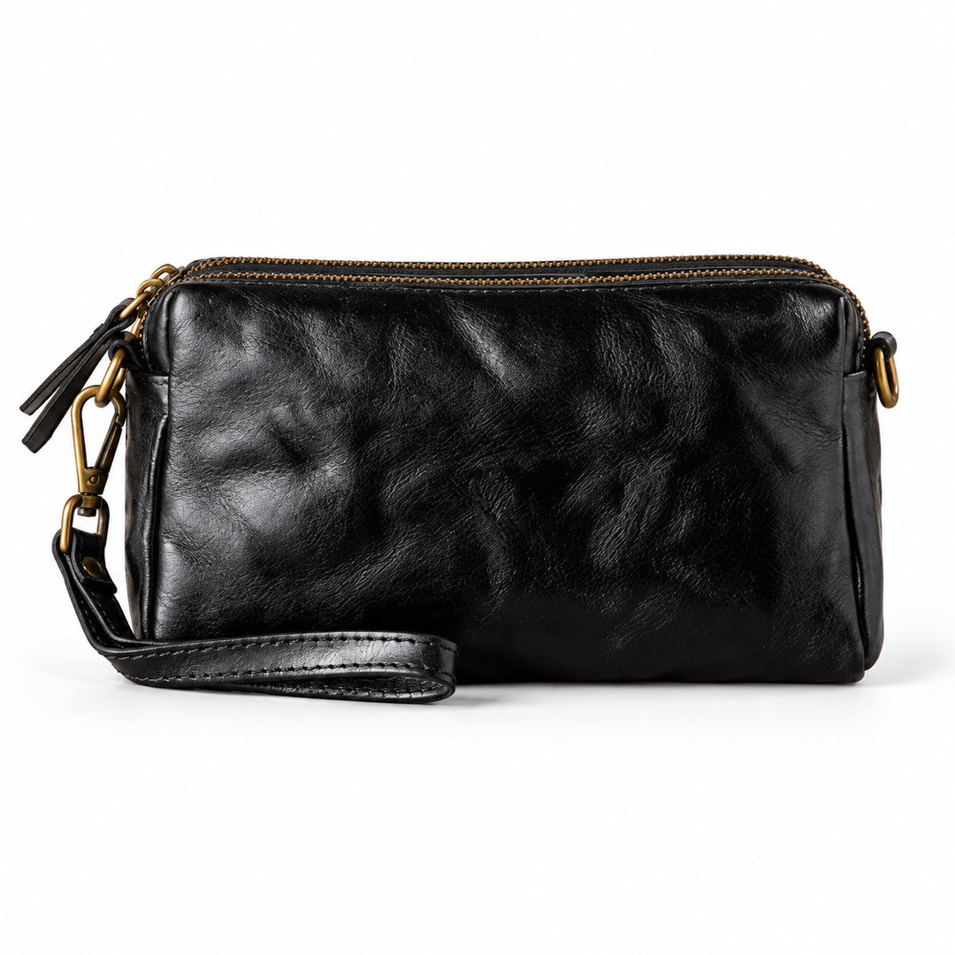 Black leather wristlet pouch with gold-tone hardware and a top zipper.