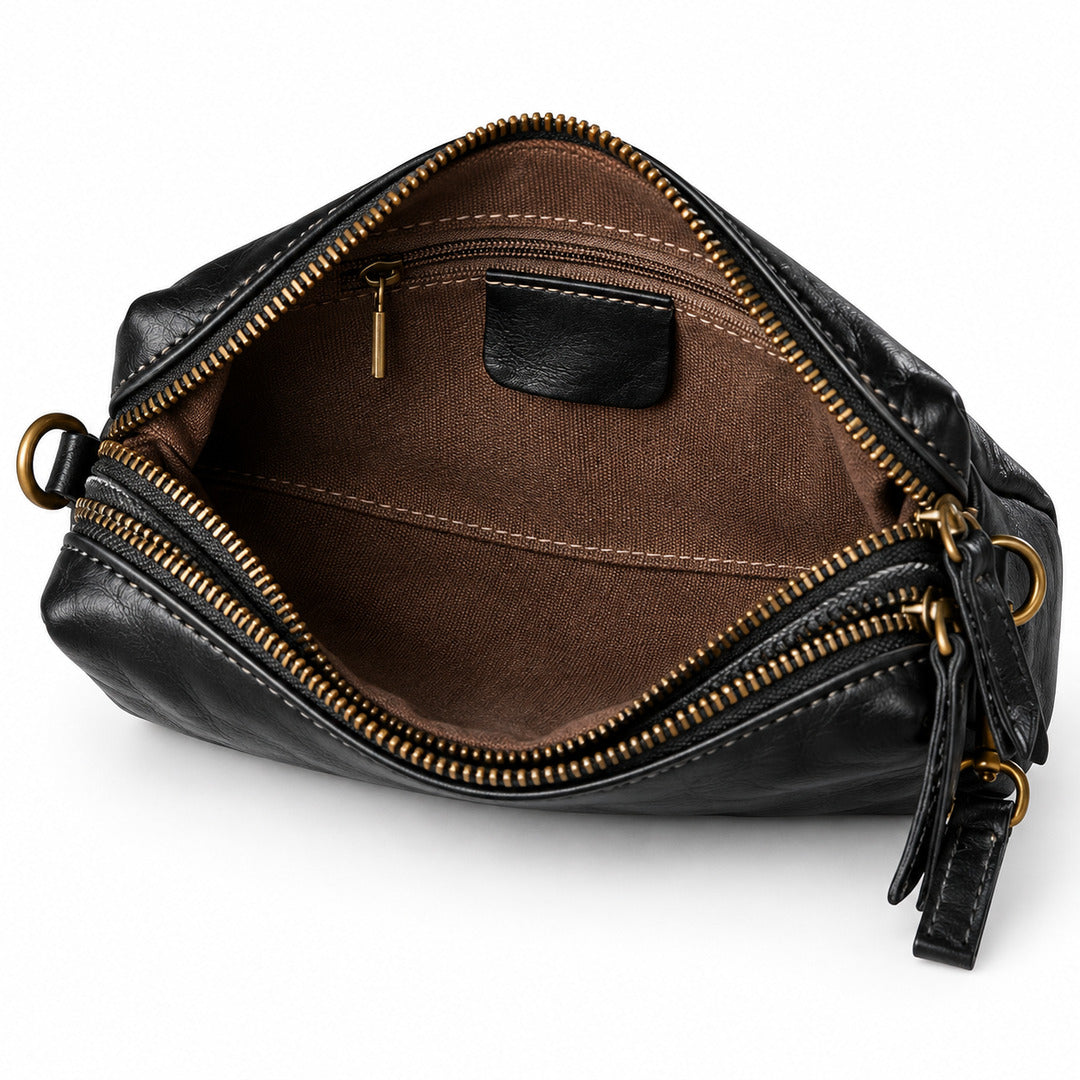 An open black leather pouch bag with a brown fabric interior, gold-tone zippers, and gold-tone hardware.
