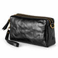 Black leather crossbody pouch with gold-tone hardware and a wrist strap, shown.