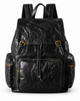 A black distressed leather backpack with gold-tone hardware, shown against a plain white background.