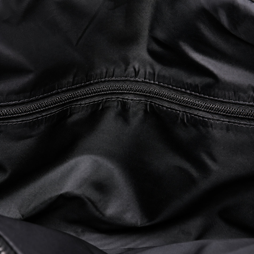 Close-up of a black nylon or polyester fabric surface with a horizontal zipper running across the center.