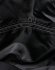 Close-up of a black nylon or polyester fabric surface with a horizontal zipper running across the center.
