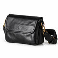Black leather crossbody bag with gold-tone hardware and a detachable shoulder strap.