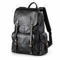 A black leather backpack with gold-tone hardware, featuring a front flap with buckle straps, a main zippered compartment, and a side pocket.