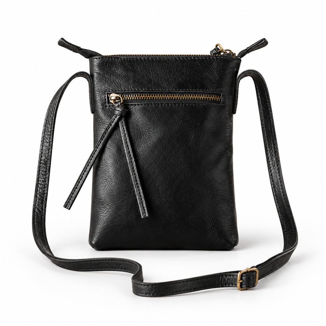 Black leather crossbody bag with a top zipper, front zip pocket, tassel detail, and adjustable shoulder strap.