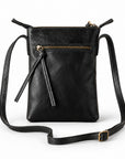 Black leather crossbody bag with a top zipper, front zip pocket, tassel detail, and adjustable shoulder strap.