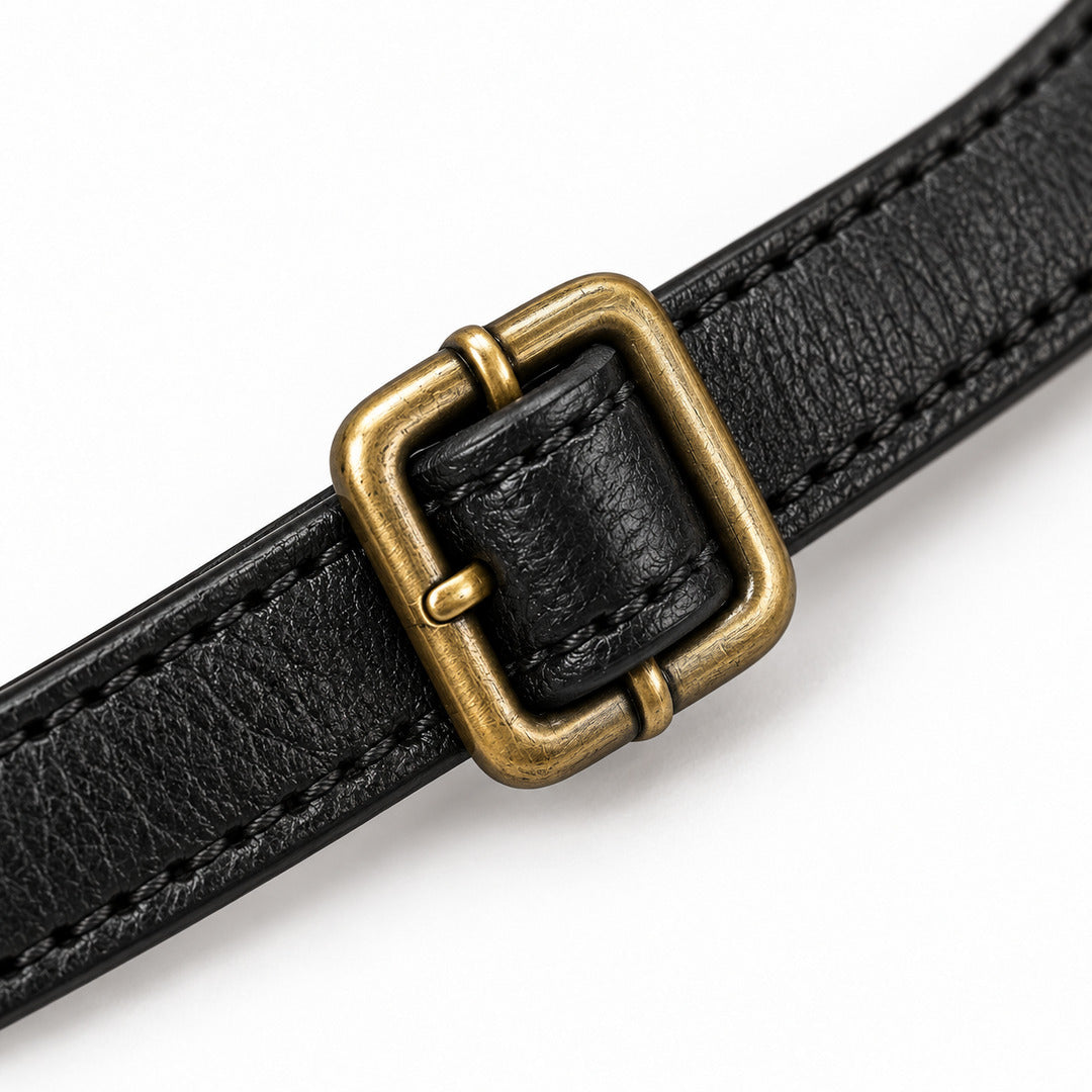 A close-up of a black textured leather strap with a square antique bronze buckle, shown on a clean white background.