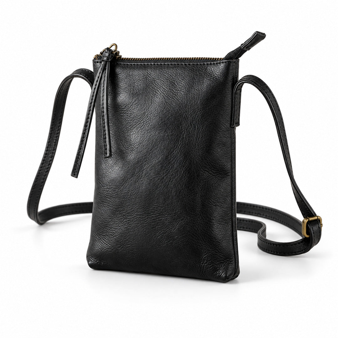 Black leather crossbody pouch bag with a top zipper, tassel detail, and adjustable shoulder strap on a white background.
