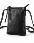 Black leather crossbody pouch bag with a top zipper, tassel detail, and adjustable shoulder strap on a white background.