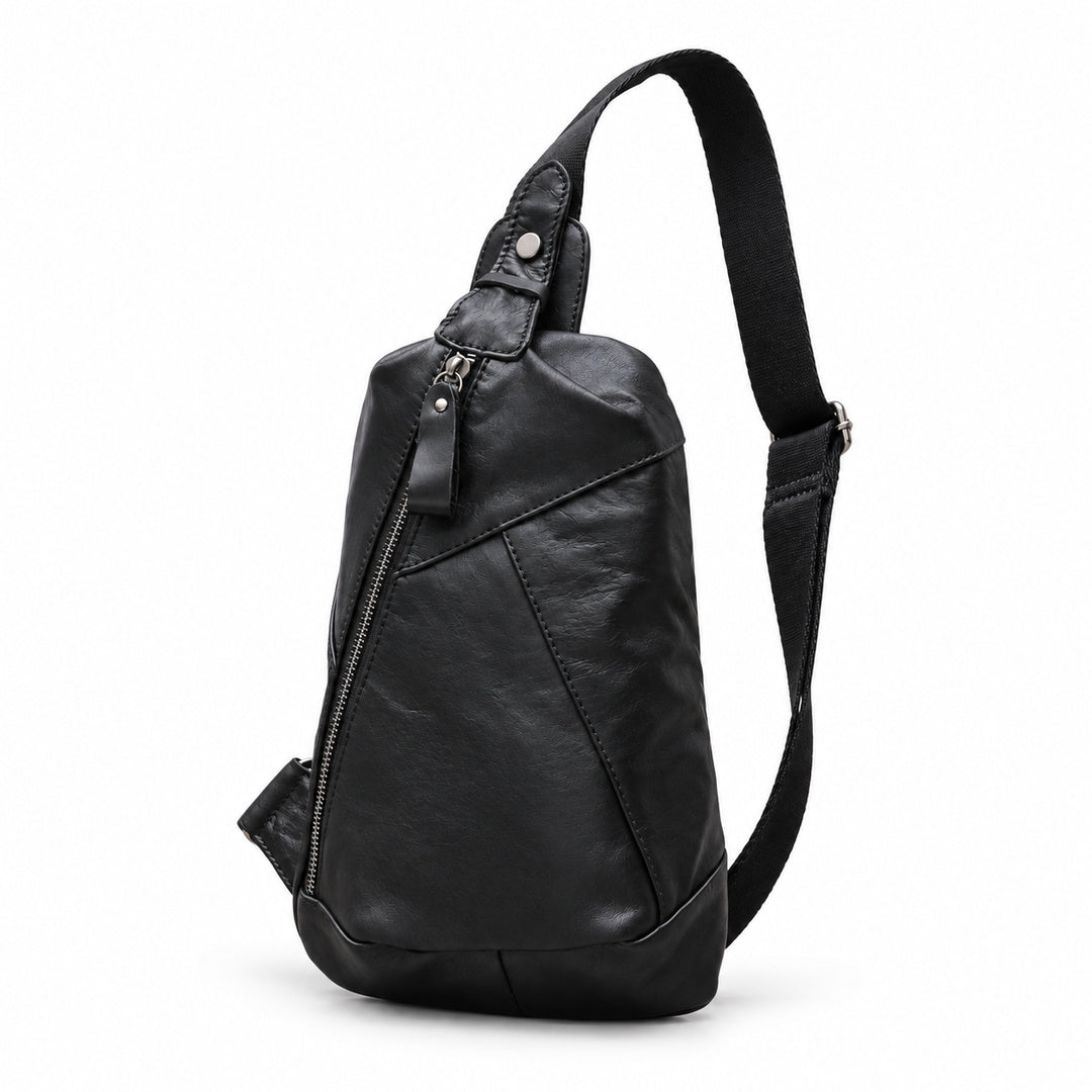 Angled view of a black leather sling bag showing its tapered shape and adjustable shoulder strap.