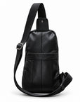 Back view of a black leather sling bag showing the rear slip pocket and adjustable strap.