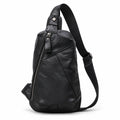 Black leather sling bag with a diagonal zipper, stitched front panels and a single shoulder strap.