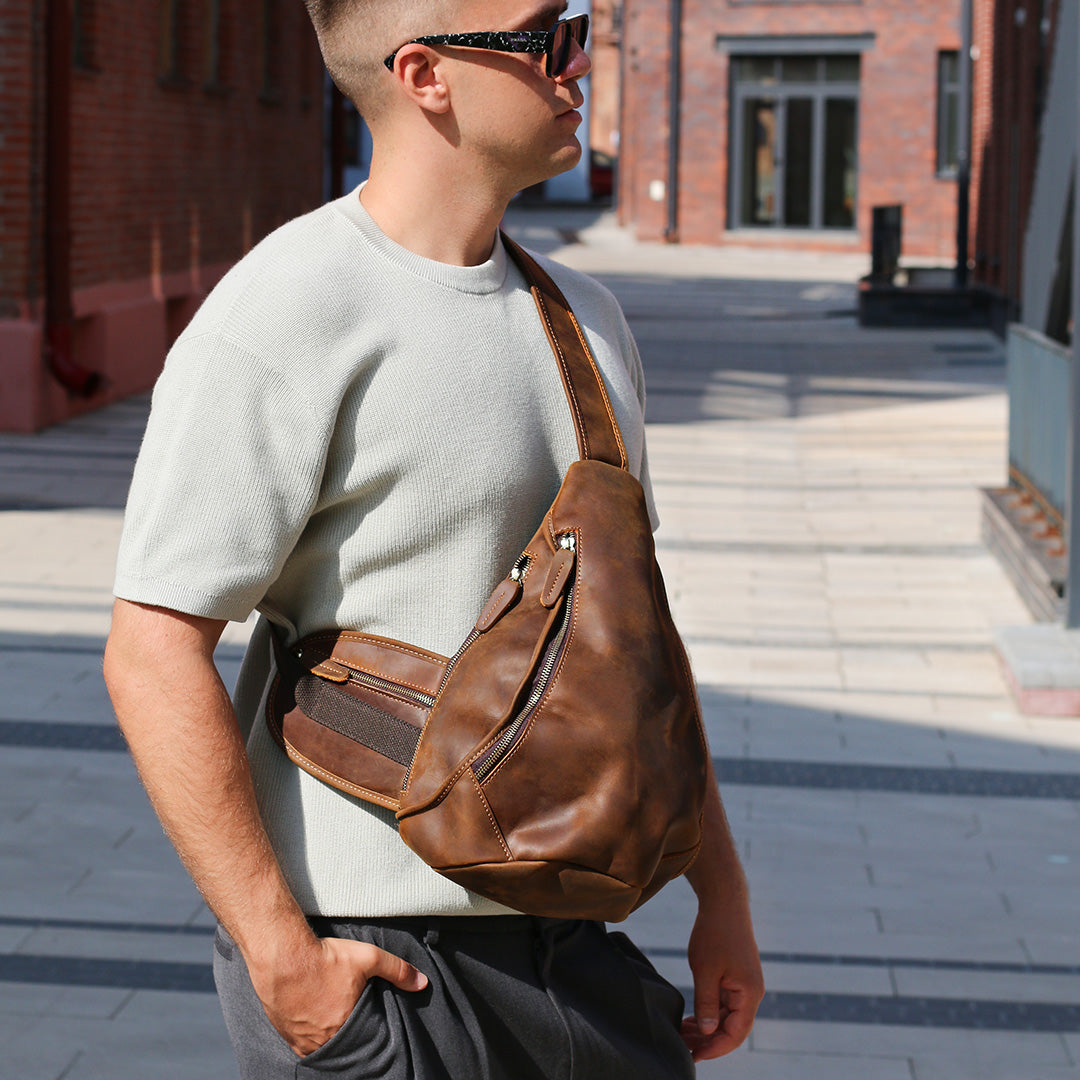 Man wearing a brown leather bag on a city street