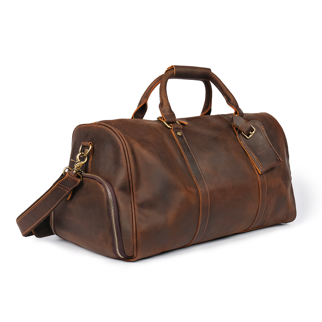 Side angle of a brown handcrafted leather weekender bag featuring premium brown leather and adjustable shoulder strap.