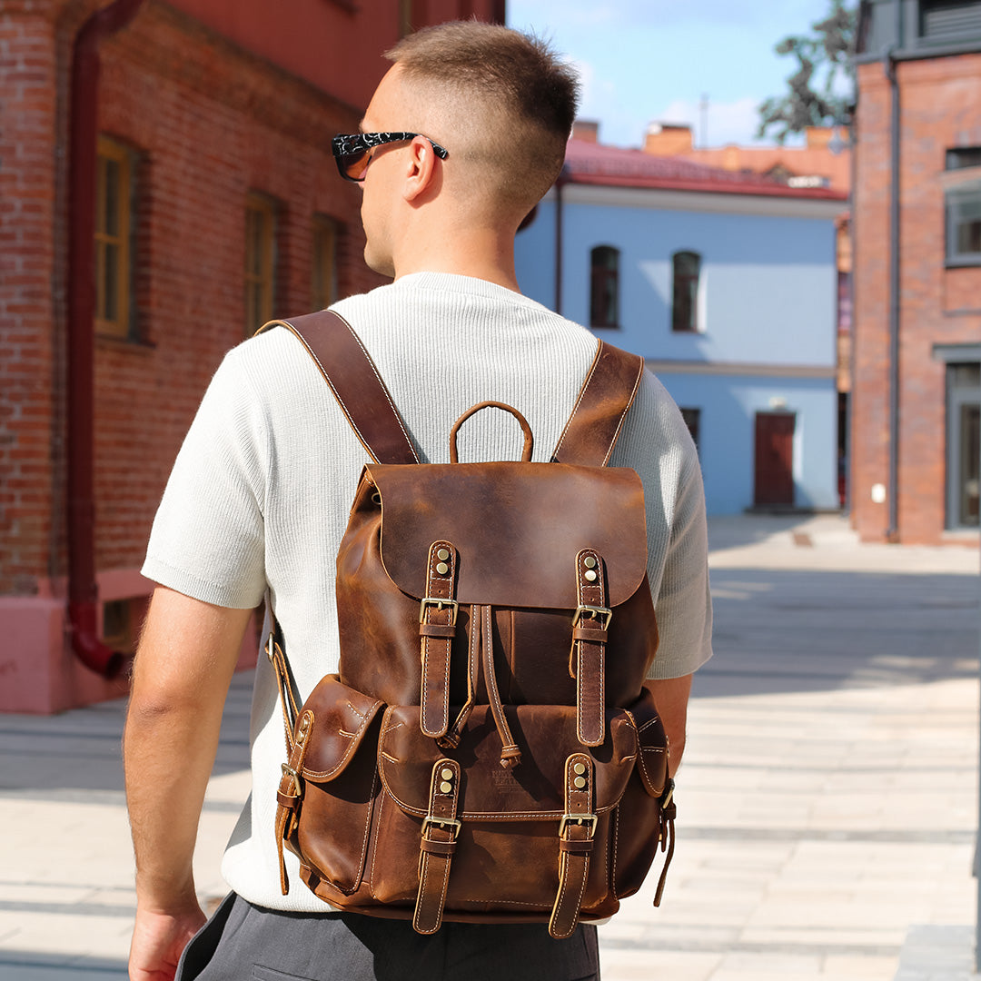 Man wearing a brown leather backpack in an urban setting