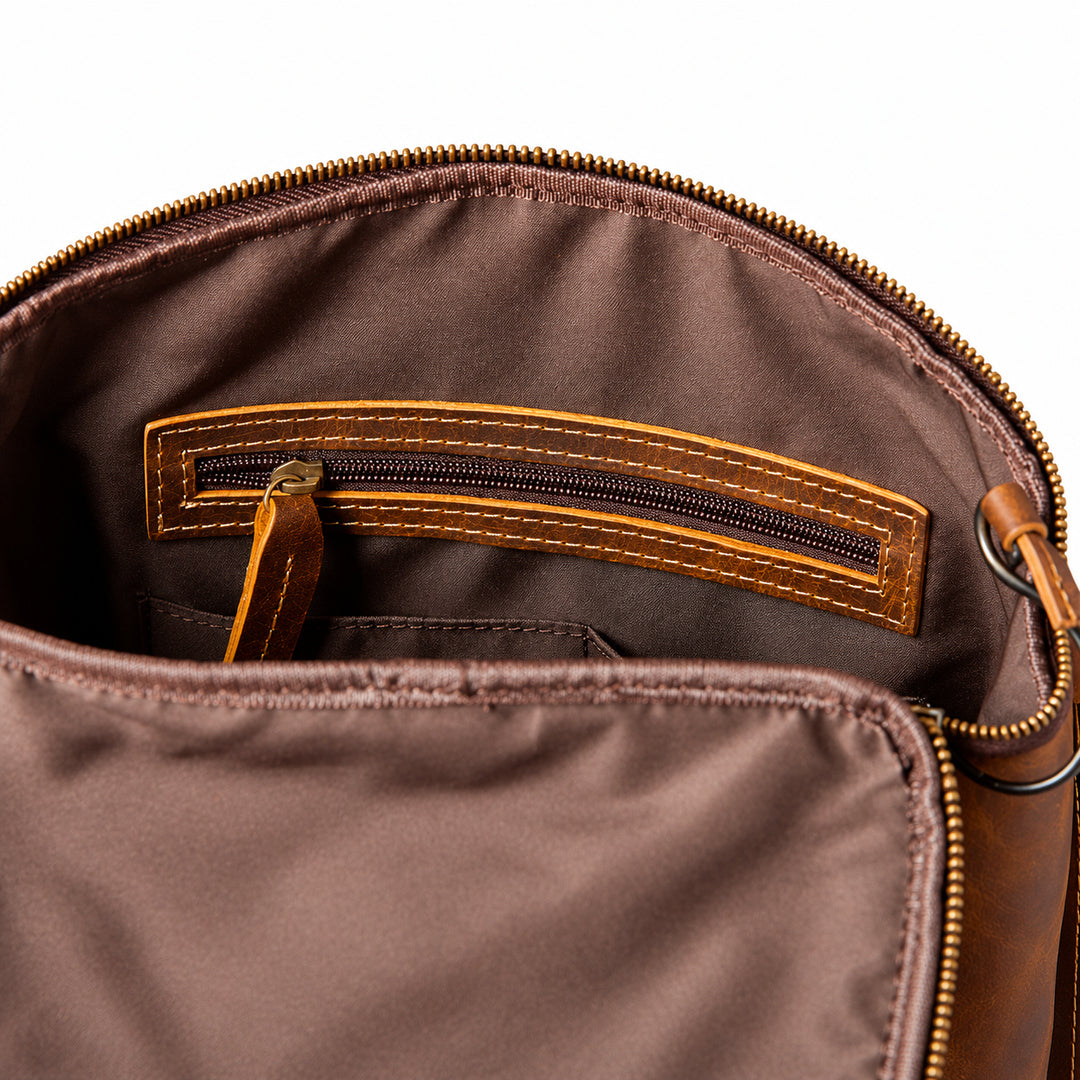 Close-up of the interior of a brown nylon bag with a gold-tone zipper, showing a brown leather interior pocket with contrast stitching and a matching zipper pull.