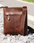 Back view of a brown Crazy Horse leather crossbody bag, showcasing its sleek design and adjustable strap.