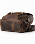 A dark brown distressed leather crossbody bag with brass hardware, shown from a three-quarters angle.