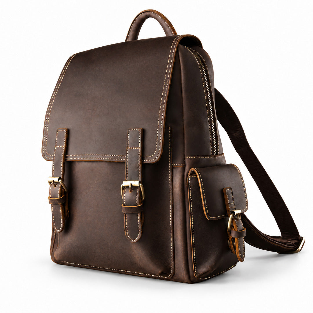 A dark brown leather backpack with brass-tone hardware, featuring a top handle, front flap with buckle straps, a zippered main compartment, and a side pocket.