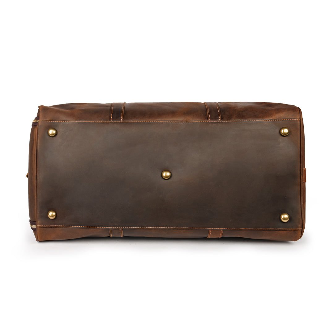 Bottom view of a brown Crazy Horse leather weekender bag with metal feet for enhanced durability during travel.