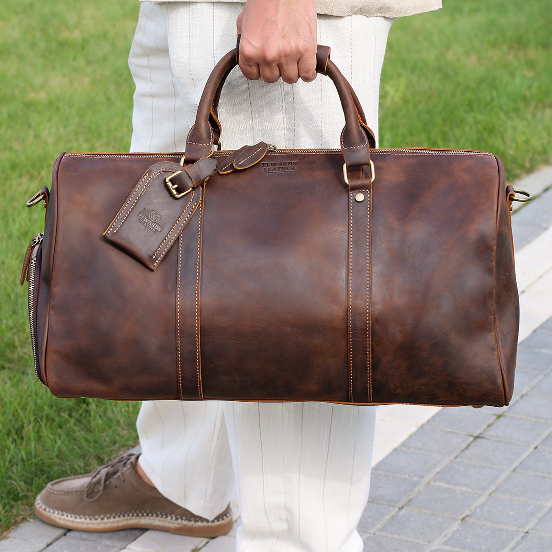 Luxury brown leather duffle bag carried by hand, perfect for stylish and practical travel.