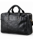 A black leather briefcase is shown in a front three-quarter view with rounded handles, paired brass-tone rivets and two zip compartments.