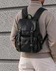 Classic black leather backpack for men with flap top, buckle straps, large front pocket and side pockets