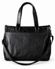 Classic black full-grain leather tote with stitched outer pocket, long handles and draped shoulder strap