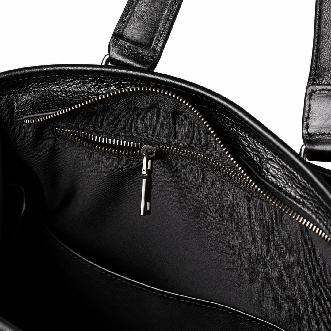 Classic black full-grain leather tote inner zipper pocket with black fabric lining and a metal pull