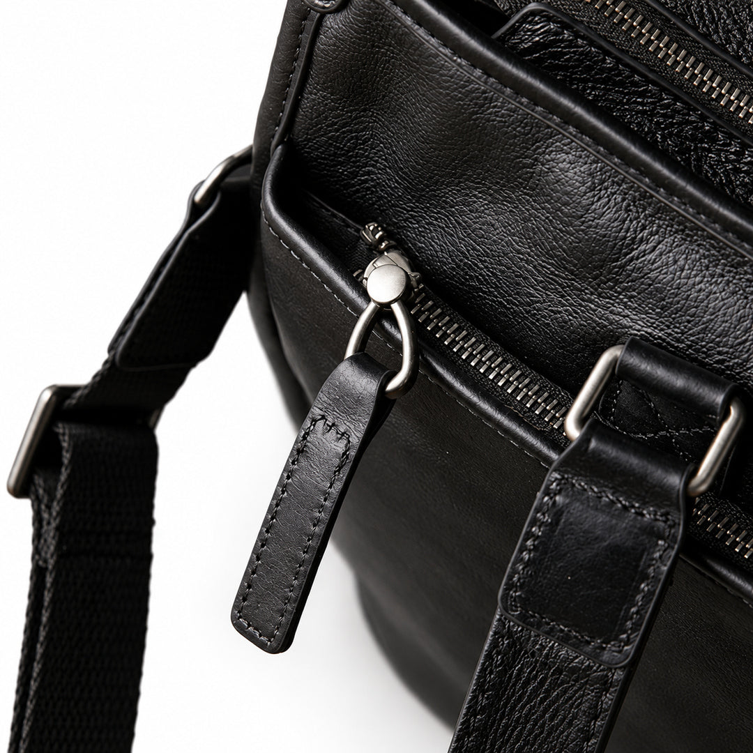 Classic black full-grain leather tote exterior zip pocket with a long leather pull and stitched handle tab