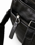 Classic black full-grain leather tote exterior zip pocket with a long leather pull and stitched handle tab