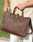 Close-up of Elwards Leather logo and vintage stitching on a brown leather bag.