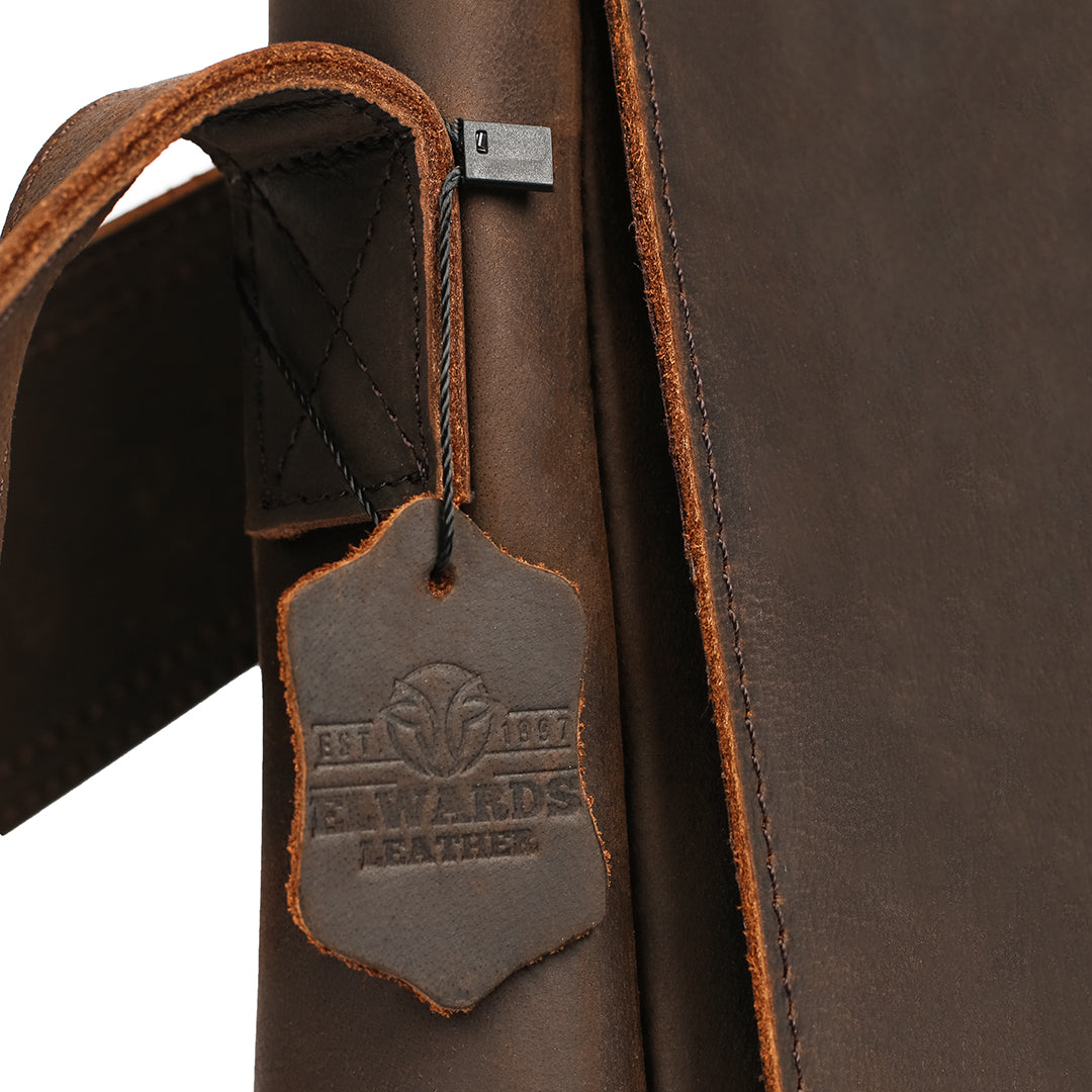 Close-up of premium men&#39;s leather bag tag with Elwards Leather logo showcasing craftsmanship