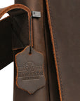 Close-up of premium men's leather bag tag with Elwards Leather logo showcasing craftsmanship