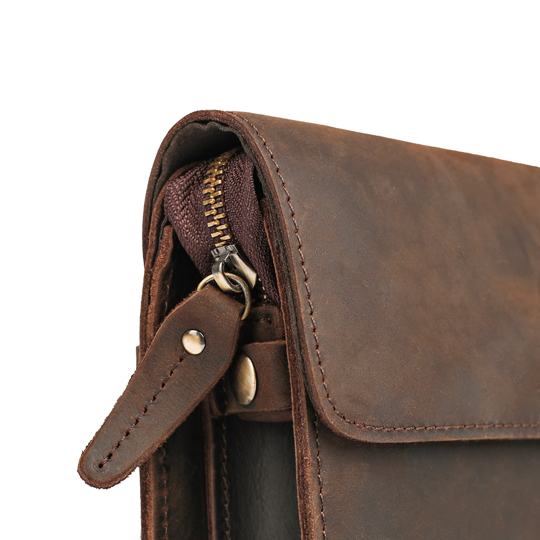 Close-up of the zip and detailing on a dark brown Crazy Horse leather clutch, highlighting quality and craftsmanship.