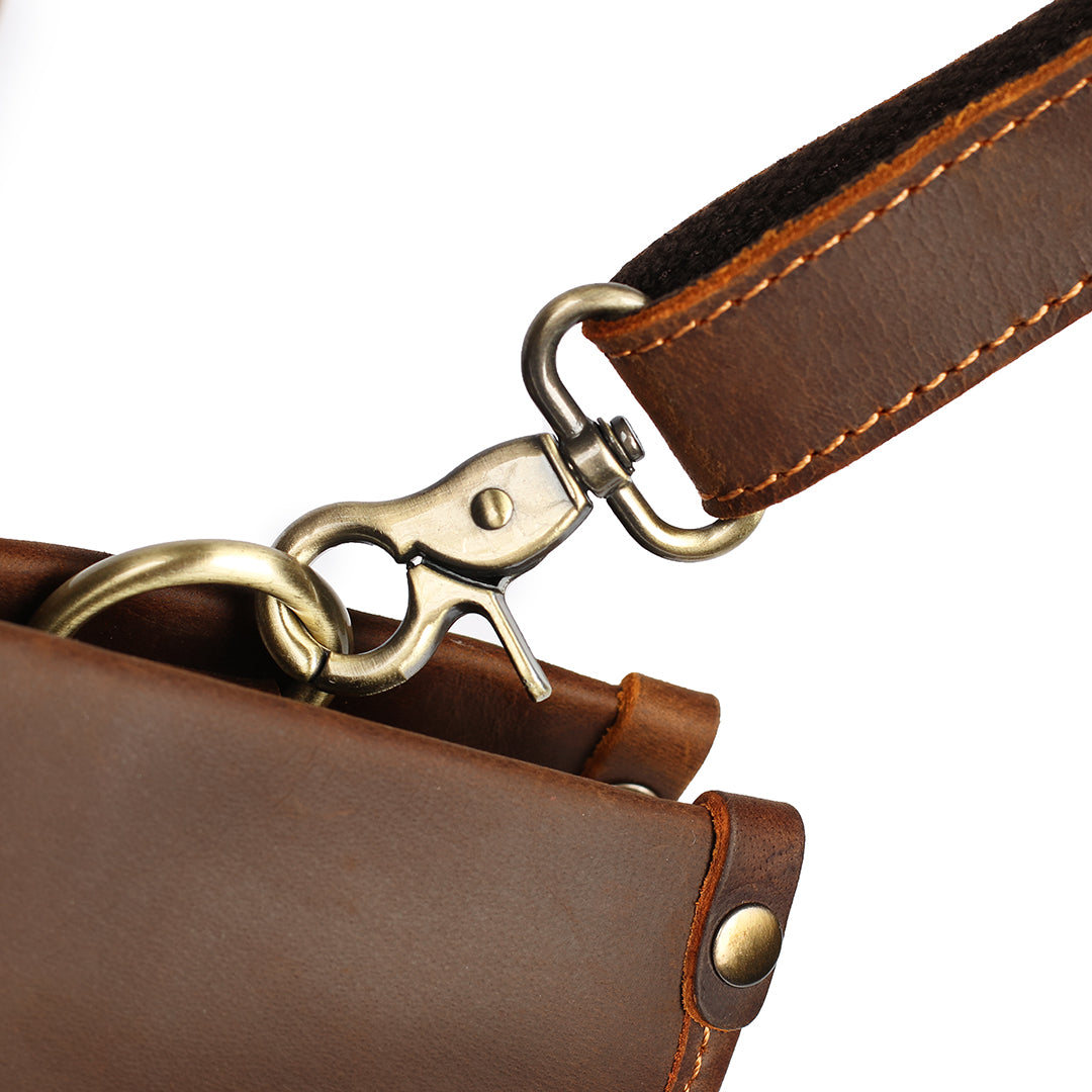 Detailed view of the leather handles and reinforced stitching on a men&#39;s brown leather work bag.