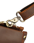 Detailed view of the leather handles and reinforced stitching on a men's brown leather work bag.