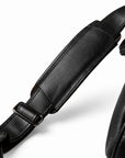 Elegant black full-grain leather duffel bag shoulder strap with leather pad and adjustment slider.