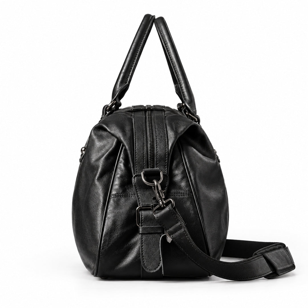 Elegant black full-grain leather duffel bag side view with zip closure and detachable strap.