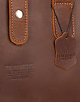 Elwards Leather logo and vintage tag on a handcrafted brown leather bag.