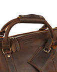 Close-up of Elwards Leather logo on premium leather duffle bag with reinforced handles and brass hardware.